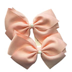 Adorable 1 pair of white and light pink ribbon bow hair clips with elegant white pearl accents, designed for little girls to wear.
